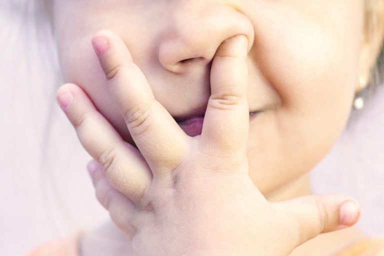 un niño se mete algo en la nariz
